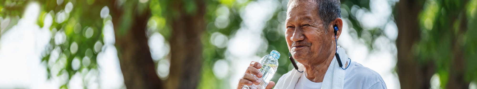 man exercising outside drinking water